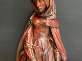 statue of a woman in a red dress with a hat on her head