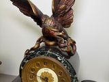 a statue of a bird sitting on top of a clock