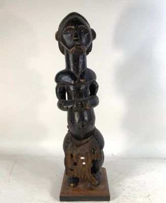 a wooden statue of a woman holding a baby