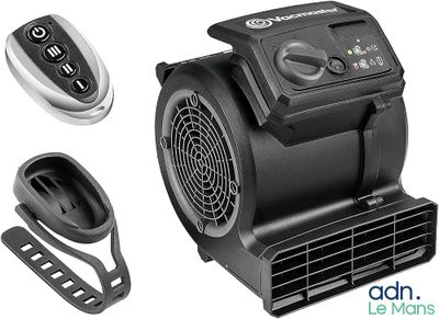 un ventilateur posé à côté d'une télécommande