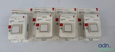 quatre interrupteurs blancs empilés les uns sur les autres sur une surface blanche
