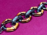 an image of a close up of a chain on a pink surface