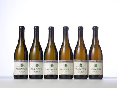 six bottles of wine are lined up on a table