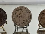 three antique coins are on display in a glass case