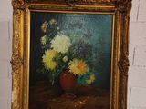 une photo d'un tableau représentant des fleurs dans un vase, posé sur un chevalet