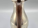 an antique silver coffee pot with a wooden handle on a white background