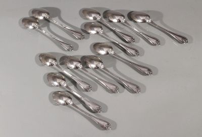 six cuillères en argent sont disposées en ligne sur une surface blanche
