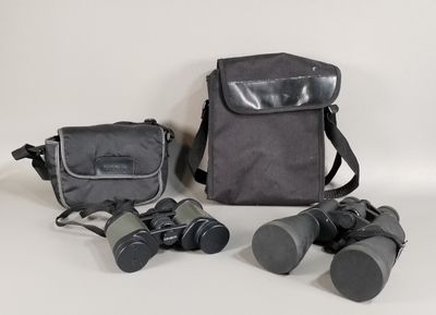 une image représentant une paire de jumelles et un sac sur fond blanc