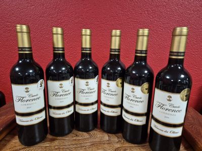 six bottles of wine are lined up on a wooden tray