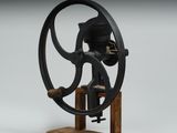 une machine à coudre à l'ancienne posée sur un support en bois, sur un fond gris