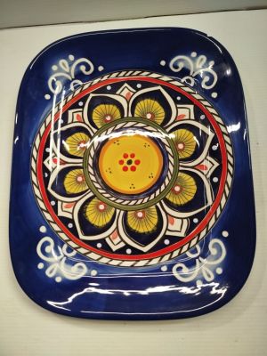 a blue plate with a yellow flower on it