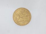 a close up of a gold coin on a white surface