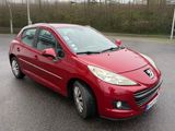 La voiture rouge est garée sur le bord de la route.
