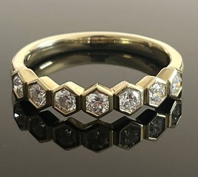 une image d'une bague en diamant sur une surface réfléchissante