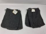 deux paires de chaussettes grises, encore étiquetées, posées sur une surface blanche