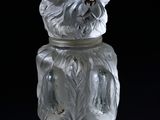 a glass bear that is sitting on a black surface
