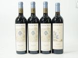 trois bouteilles de vin rouge sont alignées sur une surface blanche