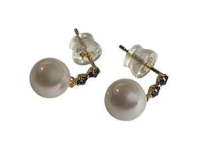 une paire de boucles d'oreilles en perles et diamants noirs sur fond blanc