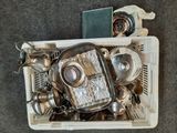 an overhead view of a container filled with silver objects on a carpeted floor