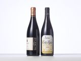 two bottles of wine sit side by side on a table