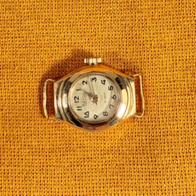 an image of a close up of a watch on a yellow cloth