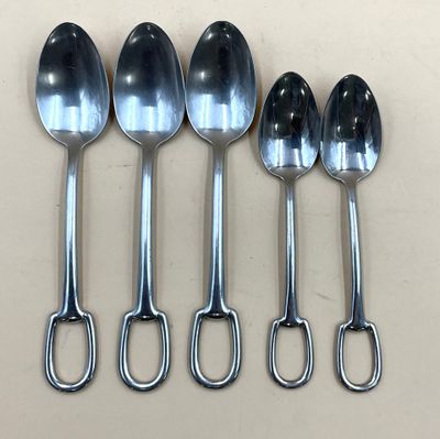 six cuillères sont alignées sur une table