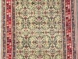 an antique persian rug with a floral design on a green ground