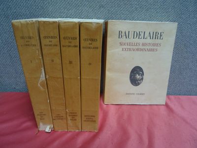 une série de cinq livres posés sur une table recouverte d'un tissu rose