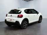 the rear of a white car parked inside of a building