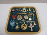 a tray that has many different types of brooches on it