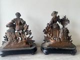 pair of antique bronze figurines of a man and a woman with a basket of flowers
