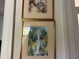 two paintings hanging on the wall above a bed