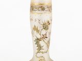 a white vase with a gold decoration on it