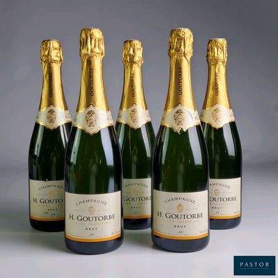 four bottles of champagne are lined up in a row