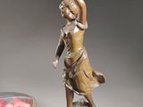 a statue of a woman holding a sword next to a vase