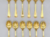 six gold spoons with numbers on them sitting on a white surface