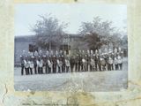 an old photo of a band of men standing in front of a building