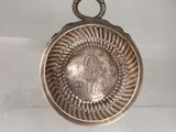 une vieille assiette en argent sur laquelle est représentée une femme