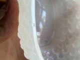 a person holding a plastic bowl with a plastic lid on it