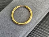 un gros plan d'une bague en or posée sur un tissu noir