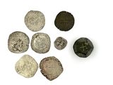 Plusieurs pièces d'argent et de bronze sont disposées sur une surface blanche