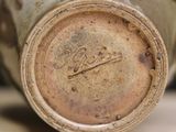 a close up of a vase with a brown lid