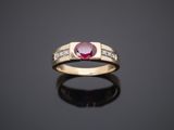 a gold ring with a ruby stone and diamonds