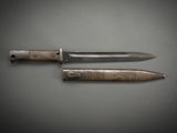 two knives are sitting side by side on a gray surface