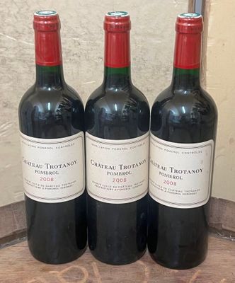 trois bouteilles de vin rouge posées sur une table en bois