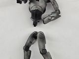 a toy figure of a robot on a white surface