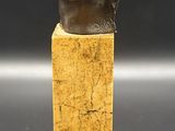 a statue of a woman ' s head on top of a wooden block
