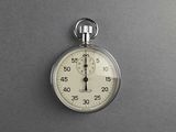a stopwatch on a gray surface with a black background