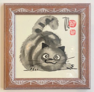 a picture of a painting of a cat hanging on a wall