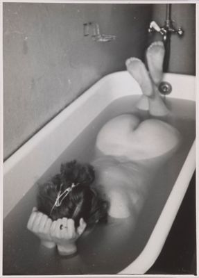 black and white photograph of a teddy bear in a bathtub